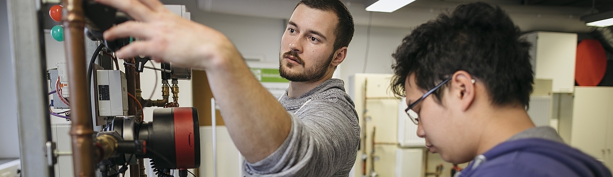 Studierende arbeiten an einer Maschine