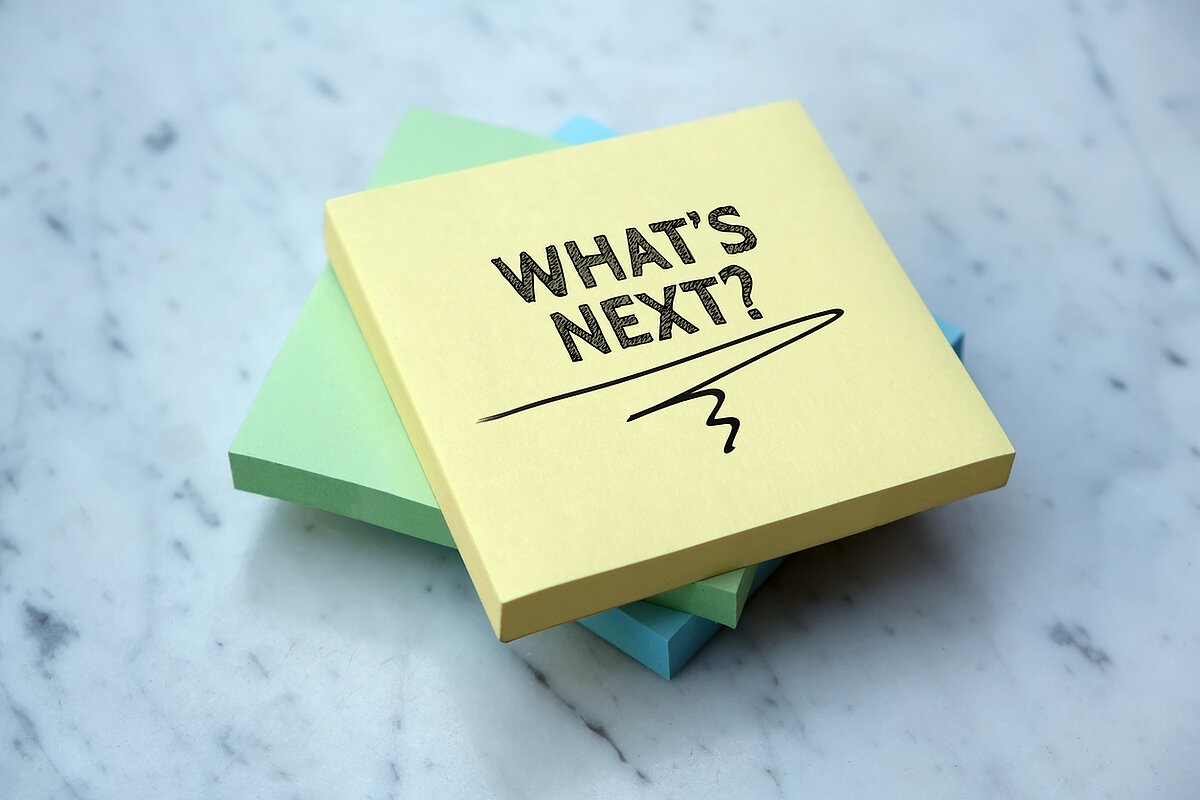Drei Post-It-Blöcke. Auf dem obersten steht: "WHAT'S NEXT?"