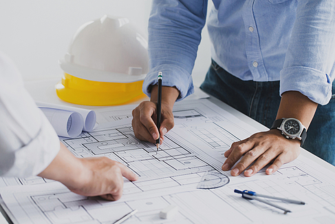 Bauplan © iStock.com - Copyright pcess609 Ingenieure arbeiten gemeinsam an Grundriss