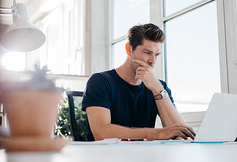 Konzentrierter Leser © iStock.com - Copyright Jacob Ammentorp Lund Mann liest konzentriert am Laptop.